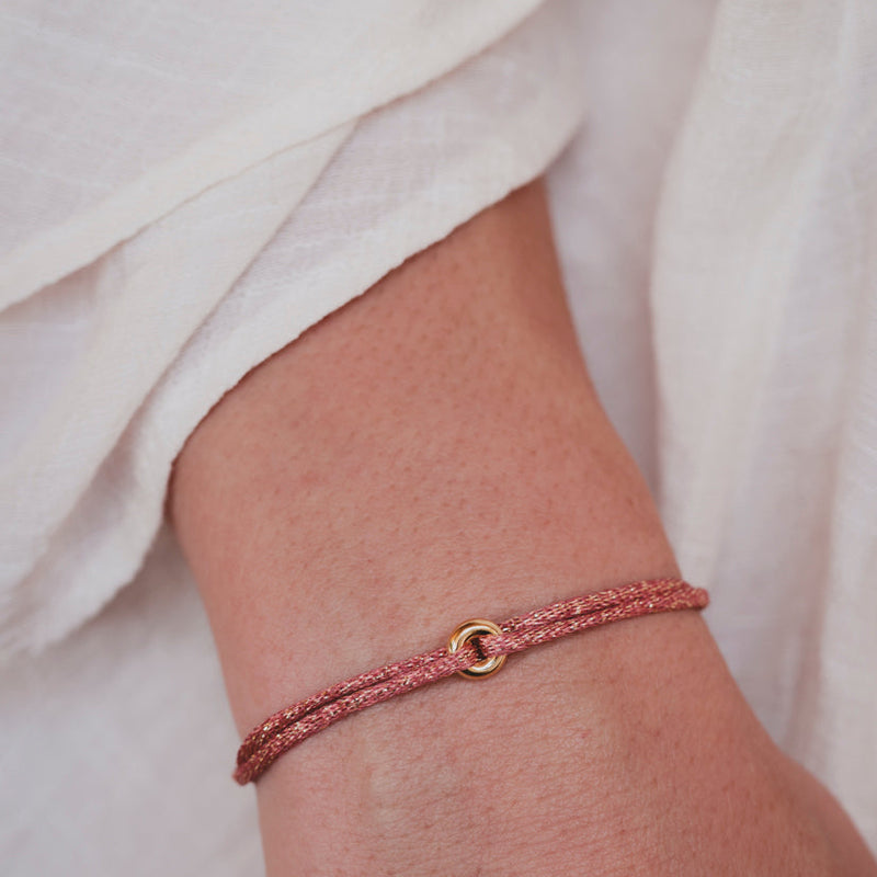 bracelet avec un donut en argent 925 plaqué or monté sur un cordon en lurex rose et doré