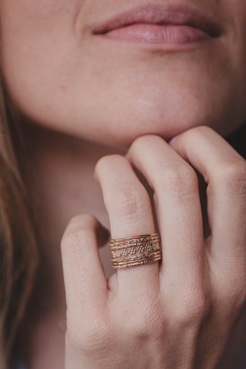 Bague dorée à motifs ciselés, trois bandes superposées sur l’annulaire