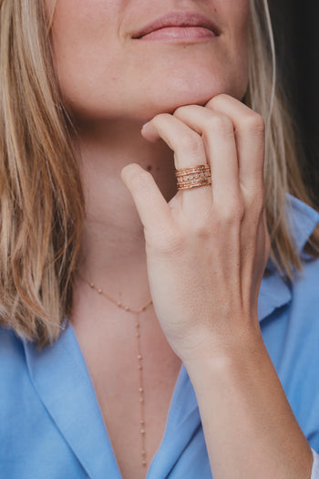 Bague dorée à trois rangs ciselés, portée sur l’annulaire