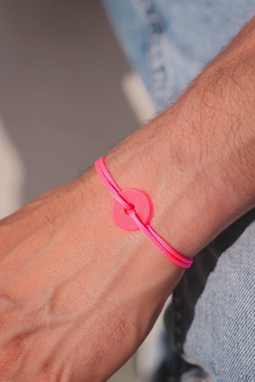 Bracelet La Cible Pop en acétate fluo rose, pastille ronde sur poignet