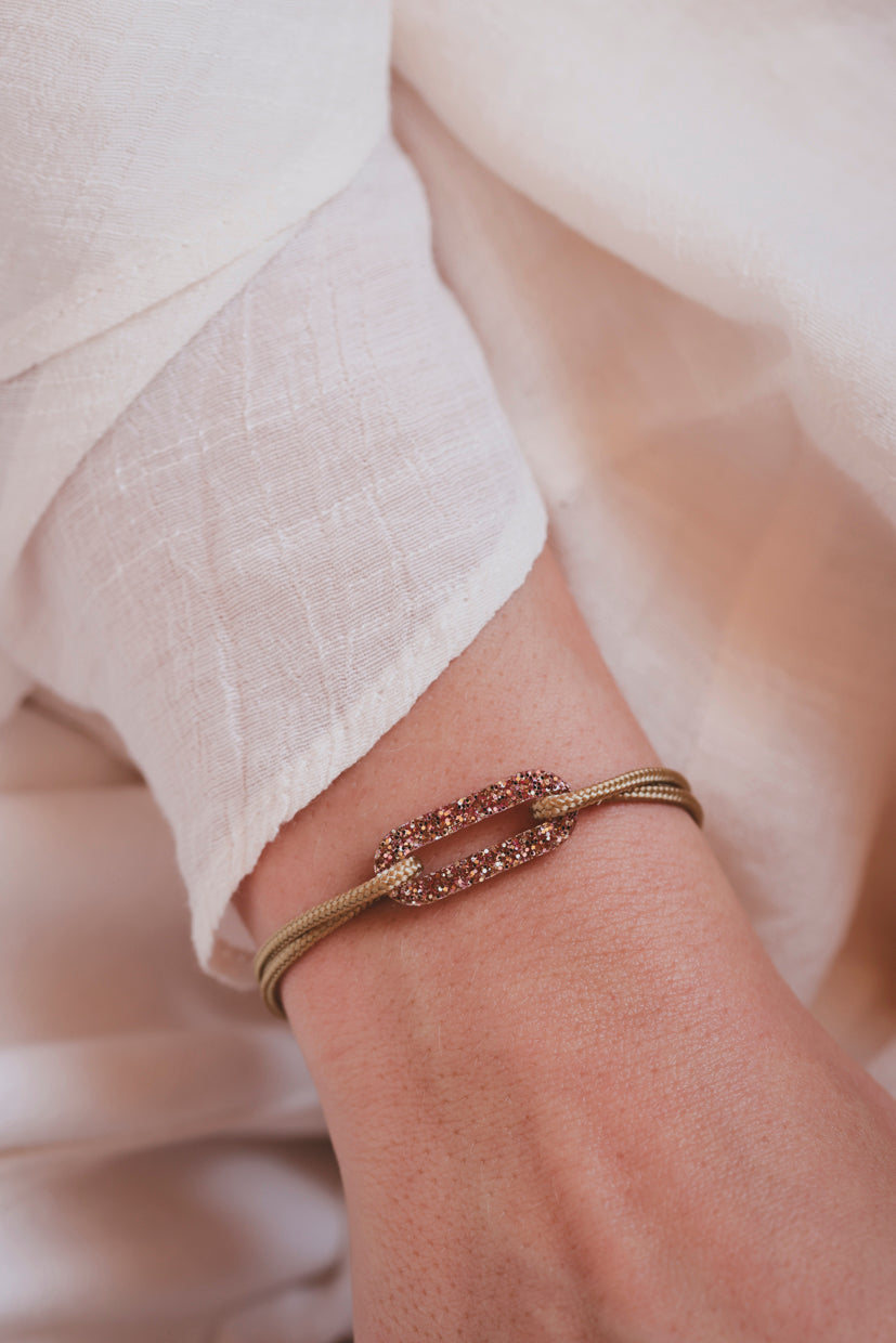 Bracelet fin doré avec maillon scintillant rose et rangée de pierres