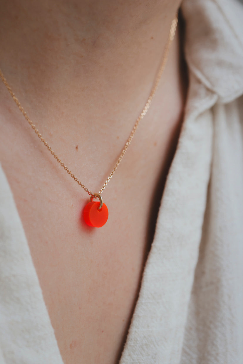 Collier fin en chaîne dorée avec pendentif galet rouge vif