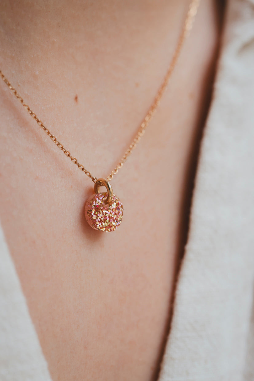 Collier en chaîne dorée avec pendentif galet pailleté orange