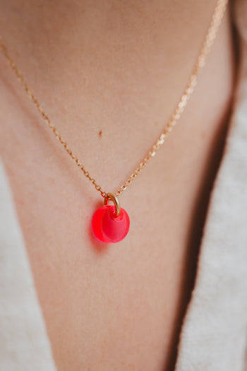 Collier à chaîne dorée avec pendentif galet rouge lumineux