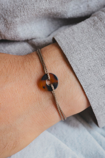 Bracelet paracorde noir avec pendentif écaille orange et attache coulissante sur poignet
