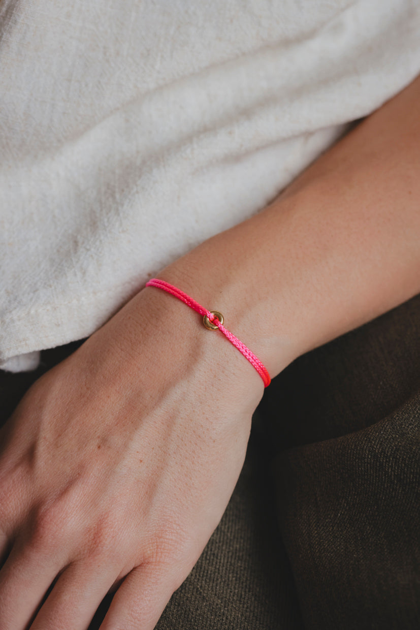 Bracelet en paracorde rose avec plaque or et attache en forme de donut