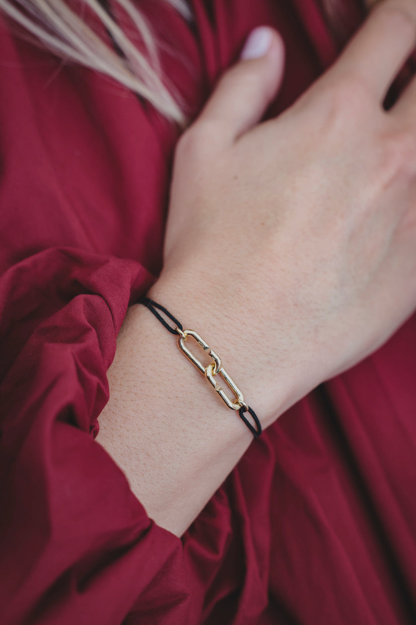 Bracelet à maillons métalliques plaqués or sur poignet, fermoir type mousqueton