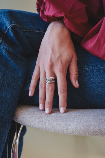 Bague argentée à motifs ondulés, anneau porté au doigt