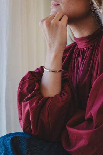 Bracelet jonc argenté avec deux petites perles, porté au poignet
