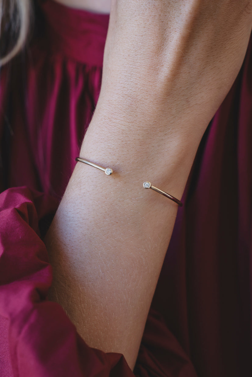 Bracelet jonc fin Aura avec petite perle ronde et fermoir fin, porté au poignet