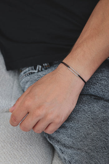 Bracelet argent 925 rhodié avec maillons rectangulaires sur cordon noir, porté au poignet
