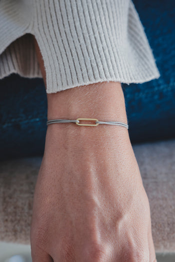 Bracelet Le Petit Maillon à plaque or, cordon beige sur poignet