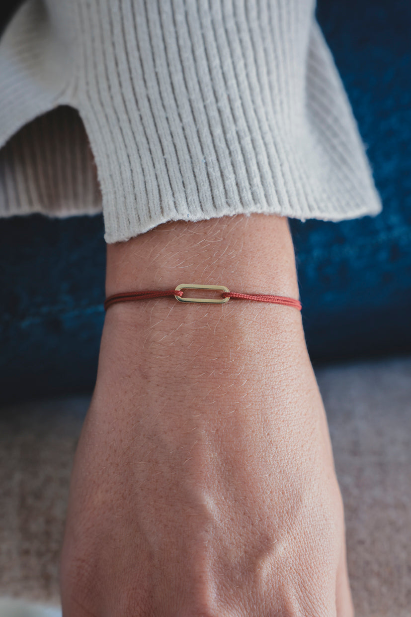 Bracelet Le Petit Maillon à plaque or, cordon marron sur poignet