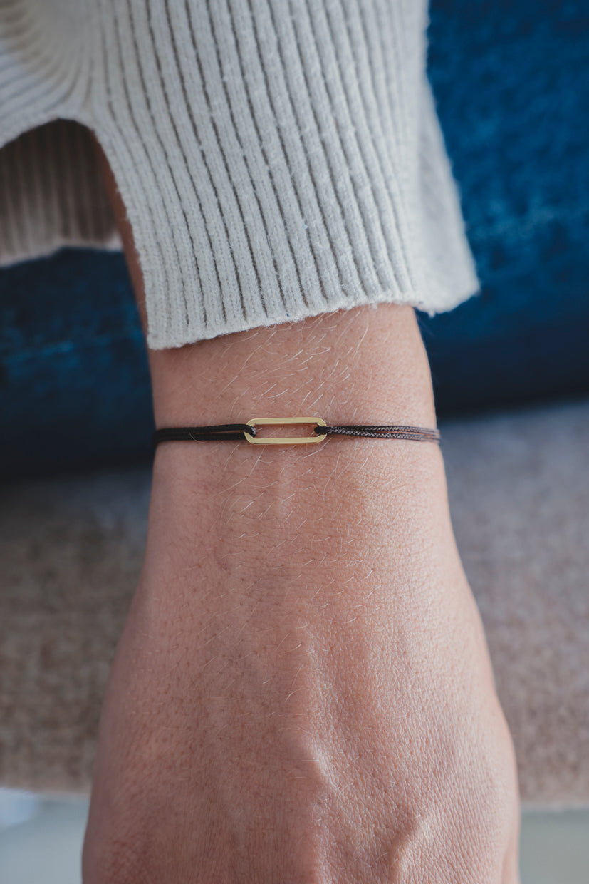 Bracelet Le Petit Maillon à plaque or, cordon noir sur poignet