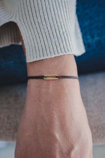 Bracelet Le Petit Maillon à plaque or, cordon noir sur poignet