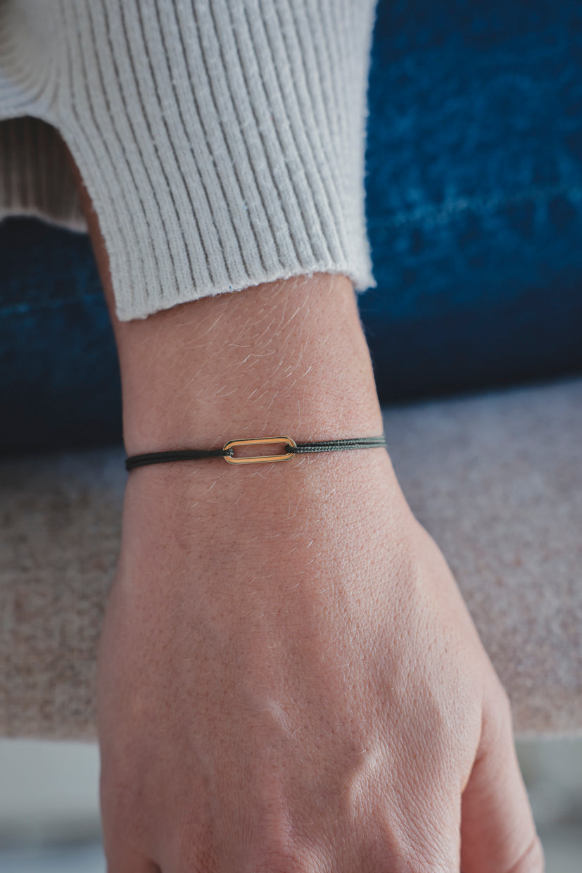 Bracelet Le Petit Maillon à plaque or, cordon brun/noir sur poignet
