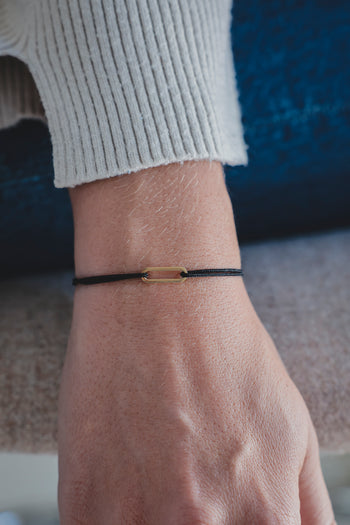Bracelet Le Petit Maillon à plaque or, cordon noir sur poignet