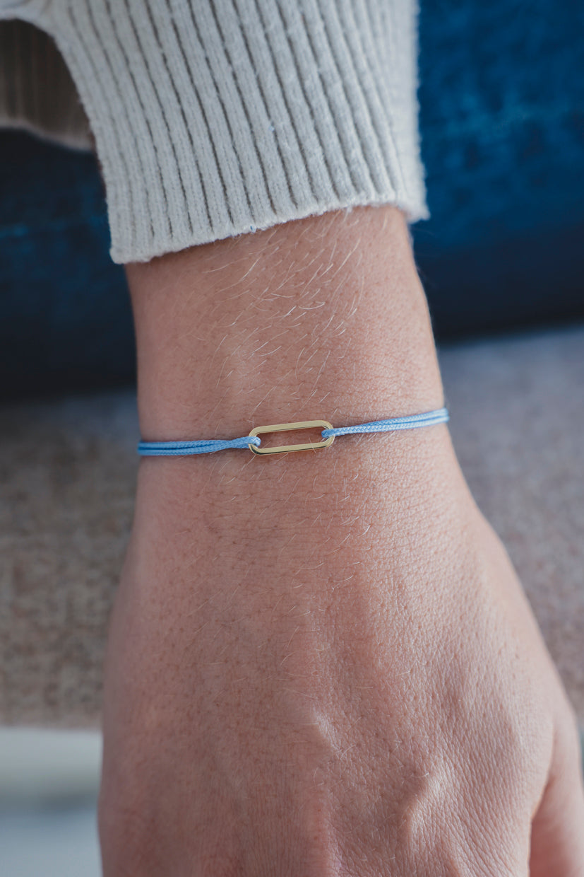 Bracelet Le Petit Maillon à plaque or, cordon bleu sur poignet