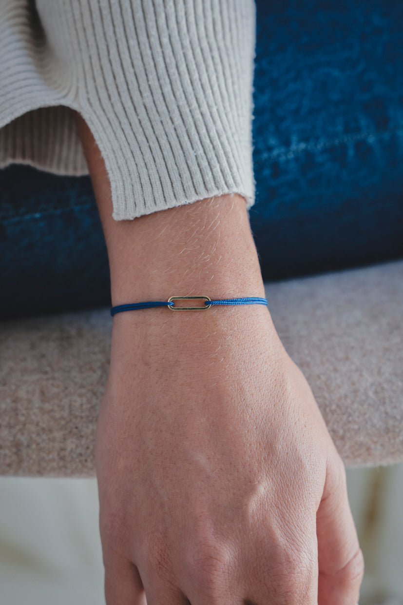 Bracelet Le Petit Maillon à plaque or, cordon bleu vif sur poignet