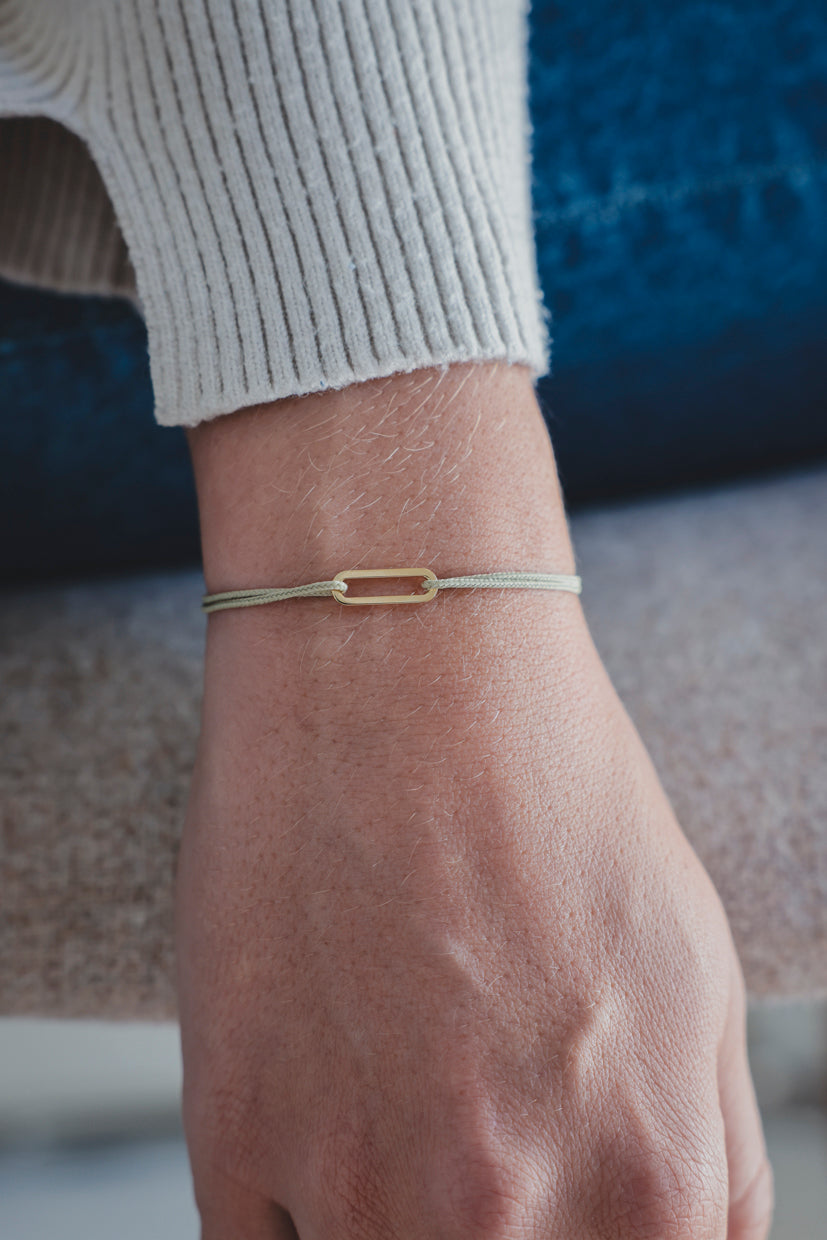 Bracelet Le Petit Maillon à plaque or sur poignet, paracorde beige