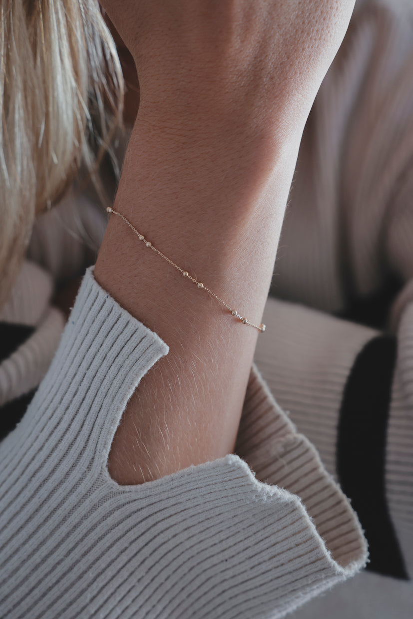 Bracelet chaîne dorée fin sur poignet, maille délicate