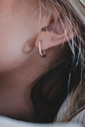 Boucle d’oreille Linea anneau fin argenté, gros plan sur le lobe