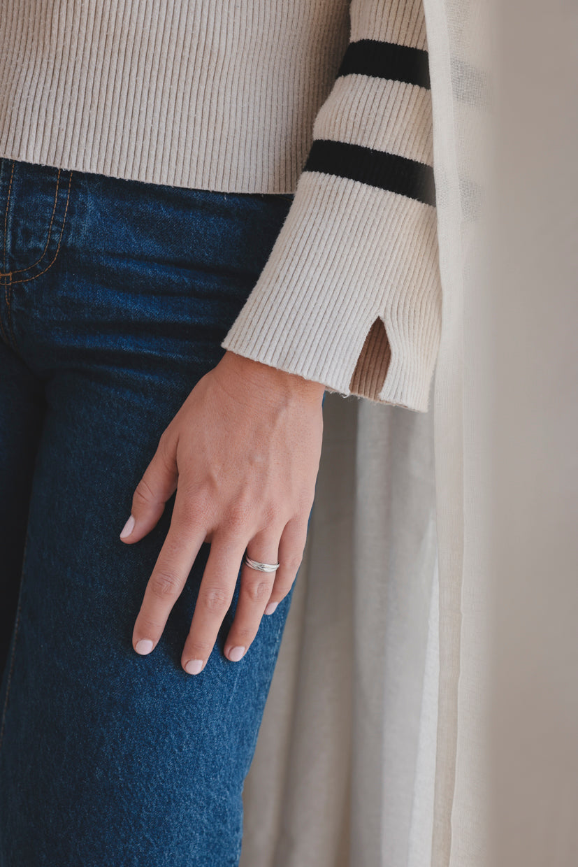 Bague fine Ondine, anneau brillant sur le doigt, portée avec pull côtelé