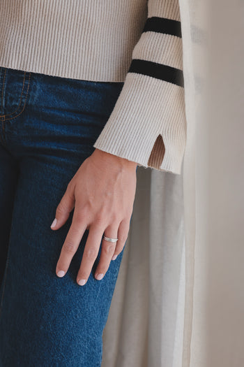 Bague fine Ondine, anneau brillant sur le doigt, portée avec pull côtelé
