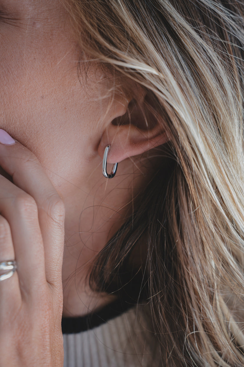 Boucle d’oreille Linea anneau fin argenté, portée, gros plan