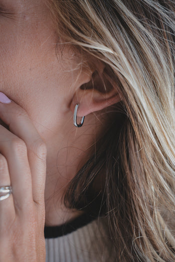 Boucle d’oreille Linea anneau fin argenté, portée, gros plan