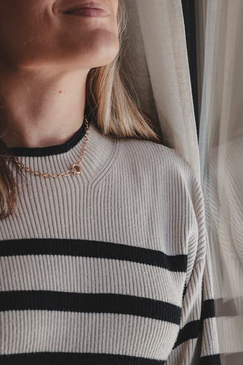 Collier chaîne dorée visible au cou, pendentif rond et maillons