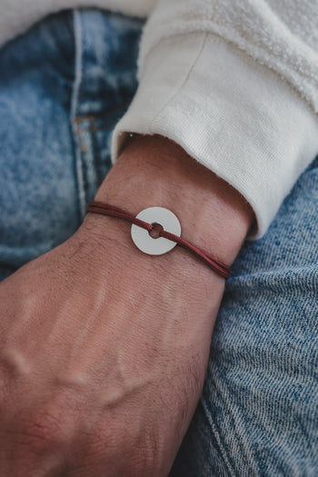 Bracelet La Cible en argent 925, cordon bordeaux et disque cible argenté.