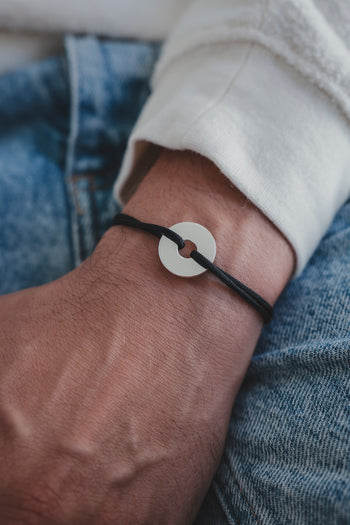 Bracelet La Cible en argent 925, cordon noir tressé et disque cible argenté.