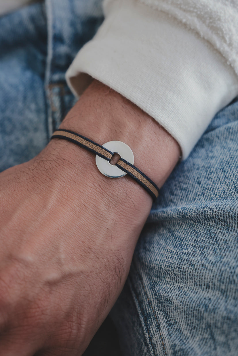 Bracelet La Cible en argent 925, cordon foncé bicolore et disque cible argenté.