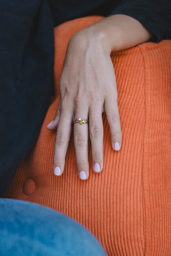 Bague Eden dorée, anneau fin avec petites pierres colorées, portée sur la main