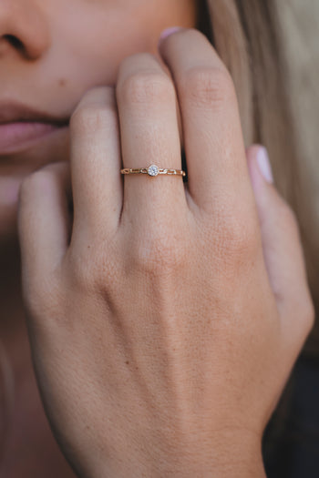 Bague dorée à pierre centrale, vue rapprochée sur l’index