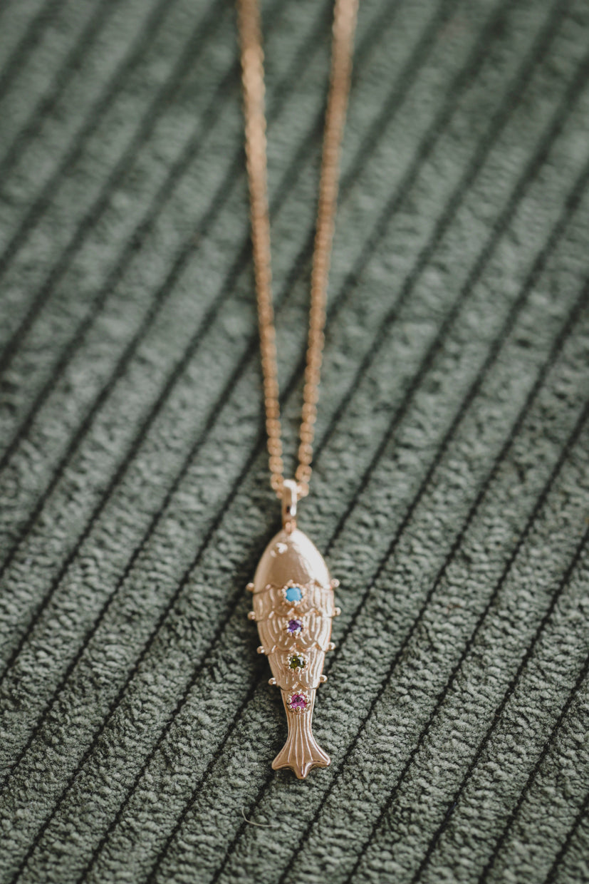 Pendentif poisson doré avec pierres bleues et violettes, sur chaîne fine
