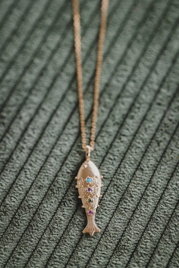 Pendentif poisson doré avec pierres bleues et violettes, sur chaîne fine