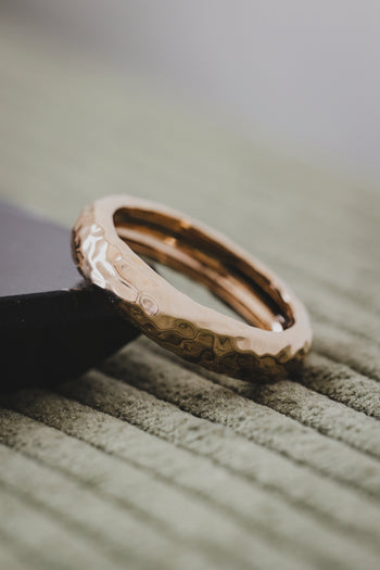 Bague Ora dorée, vue inclinée sur l’anneau texturé et intérieur brillant