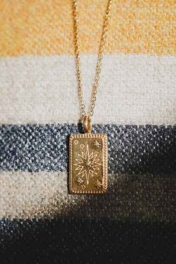 Collier Solia : petit pendentif rectangulaire motif solaire, chaîne dorée à maillons fins.