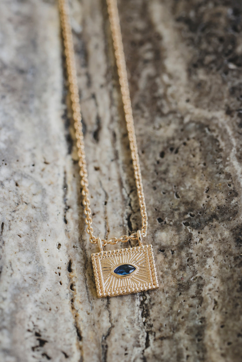 Collier avec pendentif carré doré et cabochon bleu en forme d’iris