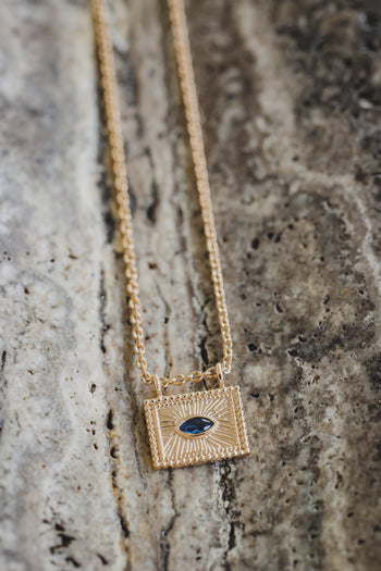 Collier avec pendentif carré doré et cabochon bleu en forme d’iris