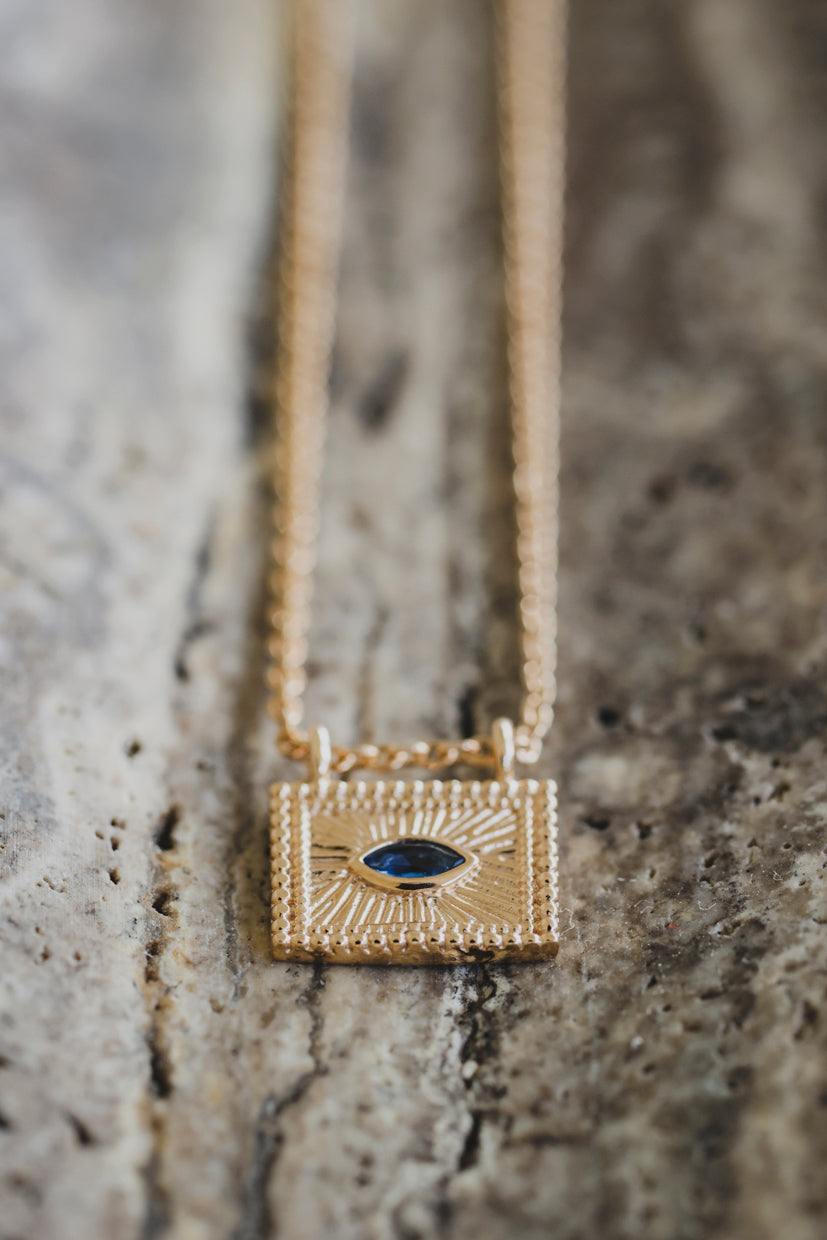 Collier avec pendentif carré doré au cabochon bleu, motif iris